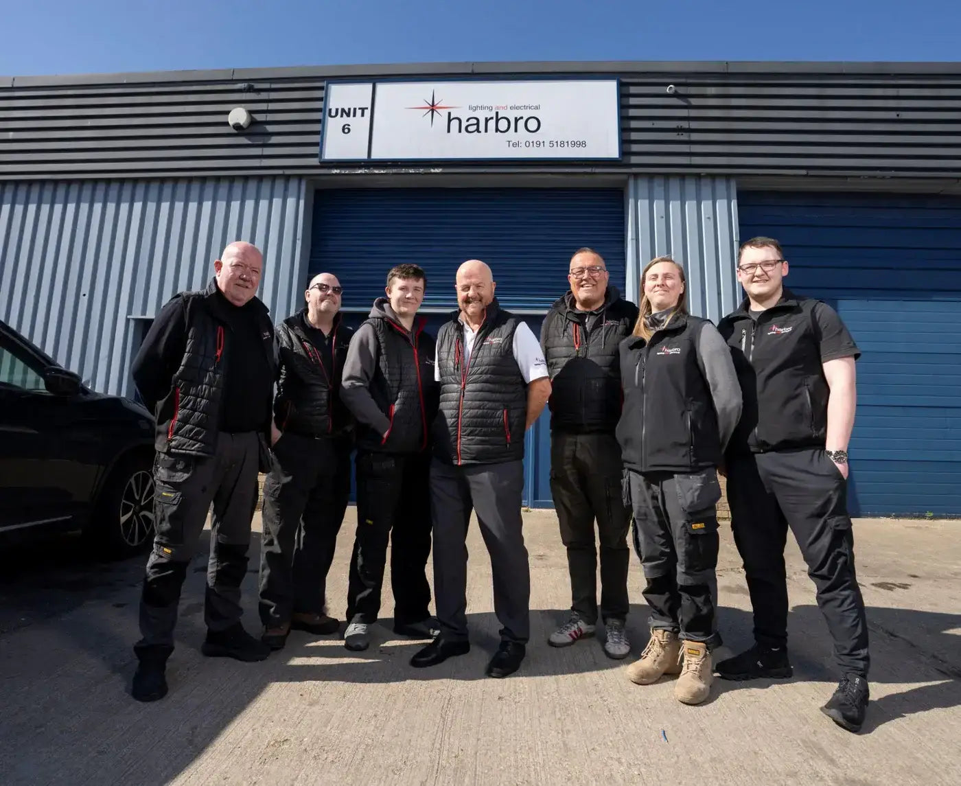 Harbro Lighting and Electrical team photographed outside their Unit 6 premises, featuring the company's branded exterior signage