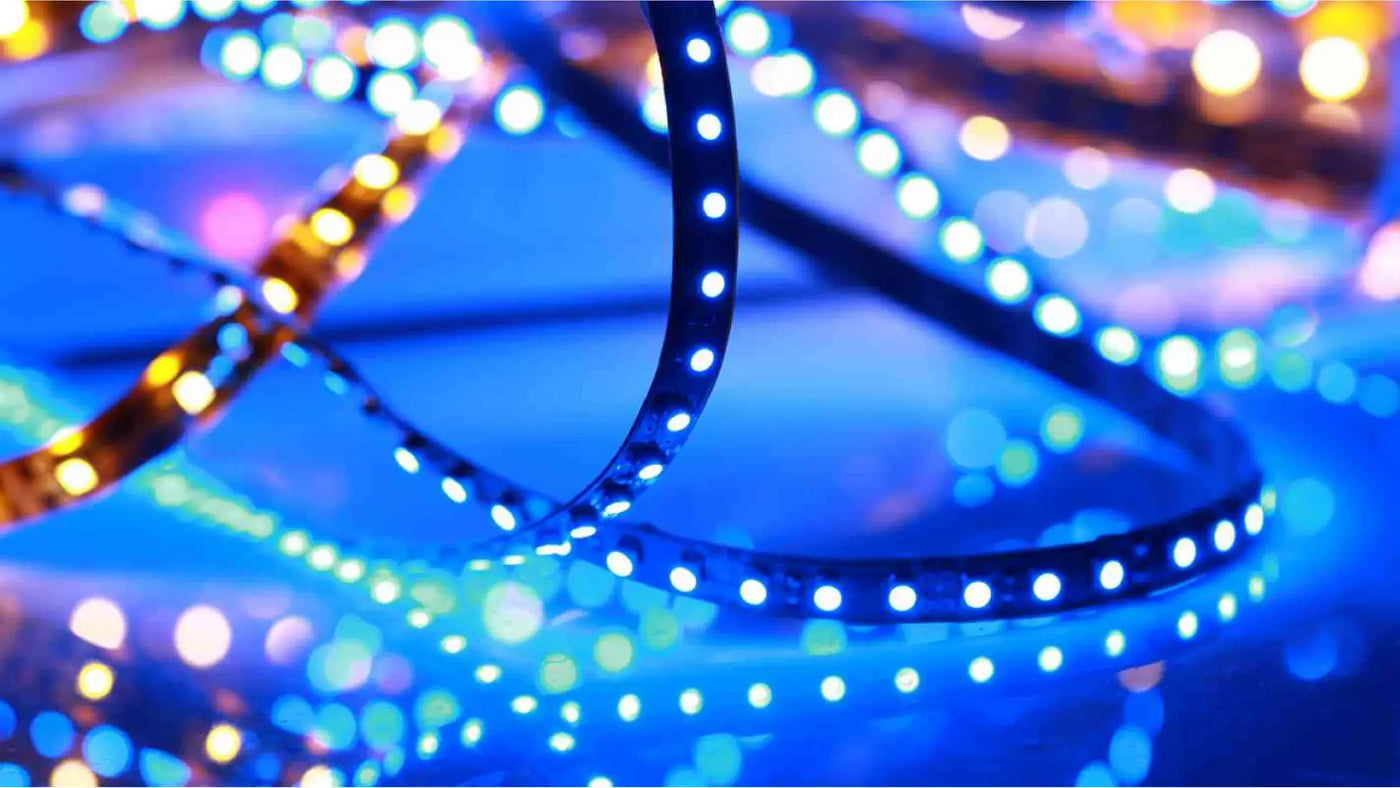 Close-up of coiled LED strip lights glowing in blue, white, and amber, with colourful bokeh light effects