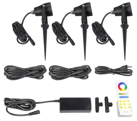 AuraLed Smart Garden Spotlight Kit contents laid flat, including three black spike-mounted spotlights with cables, a power supply unit, connectors, and an RF colour remote control